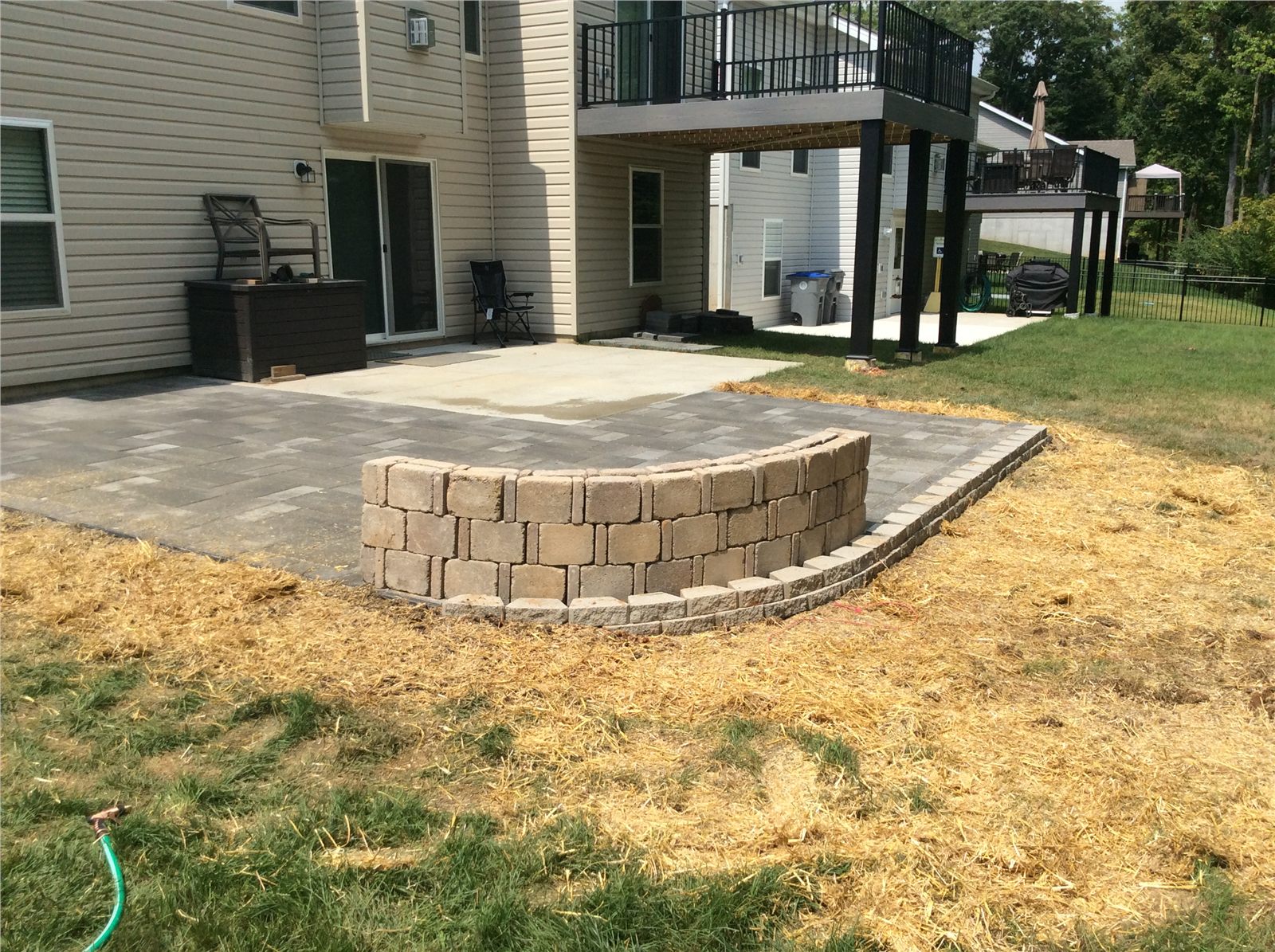 Completed paver patio with a curved retaining wall